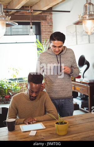Gay couple using digital tablet while having coffee at home Stock Photo