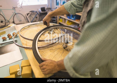 Worker repairing wheels on table at vintage bicycle workshop Stock Photo