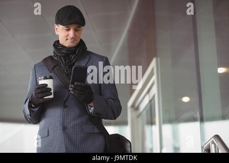 Businessman using mobile phone at the entrance of office Stock Photo