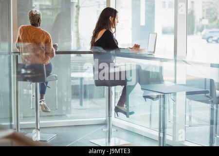 Two female executives working in office cafeteria Stock Photo