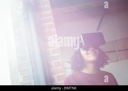 Woman using virtual reality headset at home Stock Photo