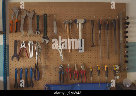 Close up of work tools hanging on racks at bicycle repair shop Stock Photo