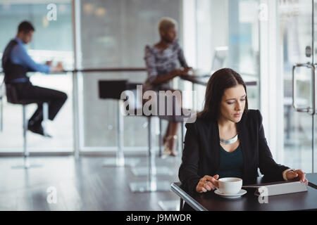 Businesswoman using digital tablet in office cafeteria Stock Photo