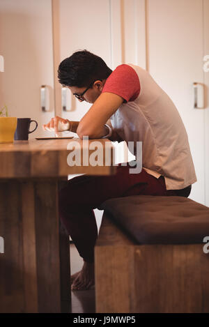 Young man using digital tablet while sitting at home Stock Photo