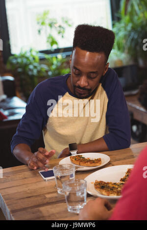 Man using phone while having breakfast at home Stock Photo