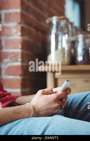 Mid-section man using mobile phone at home Stock Photo