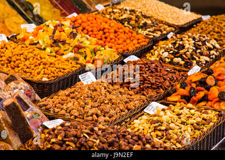 Appetizing displays of fruit, vegetables, nuts, sweets, meat, fish and cheese greet visitors to the sprawling La Boqueria market in Barcelona, Spain. Stock Photo