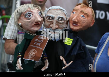 NOTE LANGUAGE ON SIGNS A demonstrator holds paper mache puppets of (left to right) Prime Minister Theresa May, Labour leader Jeremy Corbyn and Liberal Democrats leader Tim Farron outside the BBC Broadcasting House in London, where they are protesting over Radio 1's refusal to play the Liar Liar song. Stock Photo