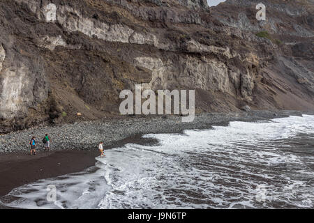 Tourists on the beach as the tide of the Atlantic Ocean comes in at Sinagoga, Santo Antao, Cape Verde. Stock Photo