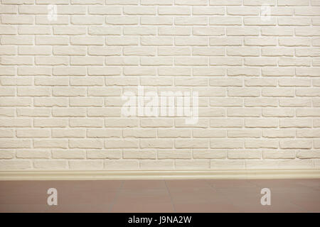 white brick wall with tiled floor, abstract background photo, yellow toned Stock Photo