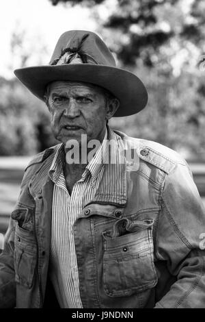 Portrait of a old man, in a cowboy hat with feather, with beard, front view  - dark isolated silhouette Stock Photo - Alamy