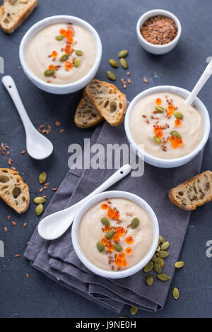 Top view of three bouls with creamy soup garnished with red caviar Stock Photo