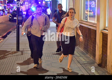 People run down Borough High Street as police are dealing with a 'major incident' at London Bridge. Stock Photo