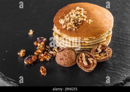 Pancake with fresh walnuts on a black surface Stock Photo