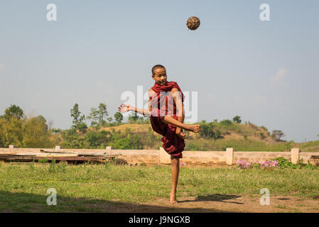 Young man kicking a wicker ball in a small village near Inle Lake, Myanmar. Stock Photo
