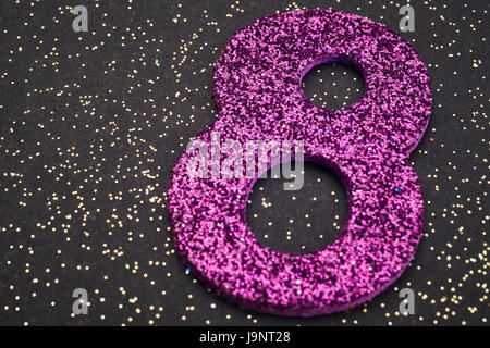 Number eight purple color over a black background. Anniversary. Horizontal Stock Photo