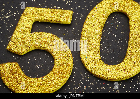 Number fifty golden color over a black background. Anniversary. Horizontal Stock Photo