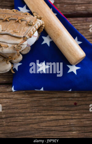 Close-up of baseball bat and gloves on an American flag Stock Photo