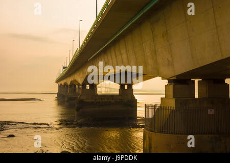 The Prince of Wales Bridge (Second Severn Crossing) during a hazy sunset over the Severn Estuary viewed from Severn Beach, Gloucestershire, England. Stock Photo