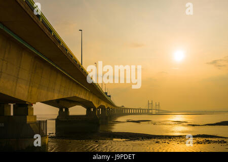 The Prince of Wales Bridge (Second Severn Crossing) during a hazy sunset over the Severn Estuary viewed from Severn Beach, Gloucestershire, England. Stock Photo