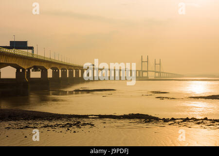 The Prince of Wales Bridge (Second Severn Crossing) during a hazy sunset over the Severn Estuary viewed from Severn Beach, Gloucestershire, England. Stock Photo