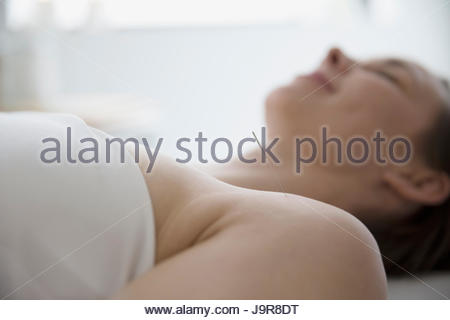 Serene woman receiving acupuncture with needle in shoulder
