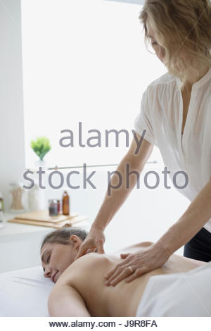 Serene woman receiving massage on spa massage table