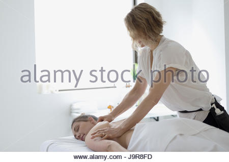 Serene woman receiving massage on spa massage table