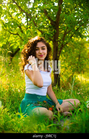 Young girl in green garden in the morning Stock Photo