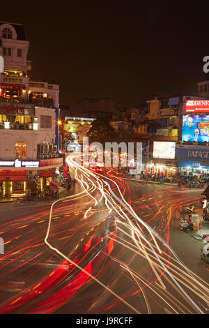 Bars, restaurants and lights from traffic at busy intersection by Hoan Kiem Lake and Old Quarter, Hanoi, Vietnam Stock Photo