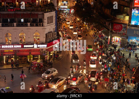 Crazy traffic at night at busy intersection by Hoan Kiem Lake and Old Quarter, Hanoi, Vietnam Stock Photo