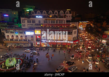 Crazy traffic at night at busy intersection by Hoan Kiem Lake and Old Quarter, Hanoi, Vietnam Stock Photo