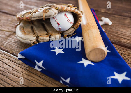 Close-up of baseball bat and gloves on an American flag Stock Photo