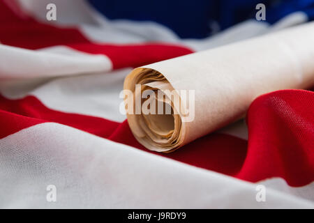 American flag with rolled-up of constitution document on wooden table Stock Photo