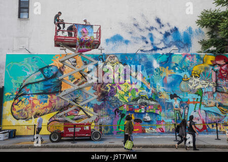 New York, NY 2 June 2016 - Korean American artist David Choe takes ta break from painting to speak with fans  in the lift, at the Houston Bowery Mural. © Stacy Walsh Rosenstock Stock Photo