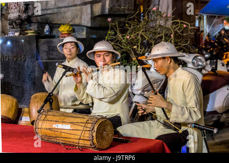 Musicians entertaining visitors shopping at the night market at Hanoi Vietnam Stock Photo