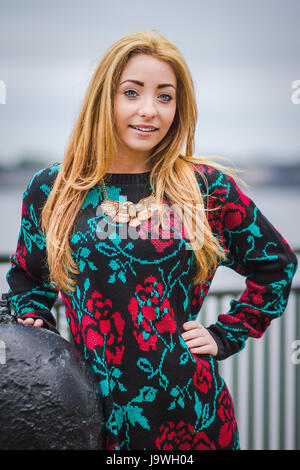 Alex leans against a large mooring on the Liverpool waterfront under some grey skies. Stock Photo