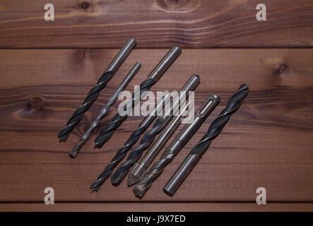 Several drills on a wooden table. Drills close-up. Stock Photo