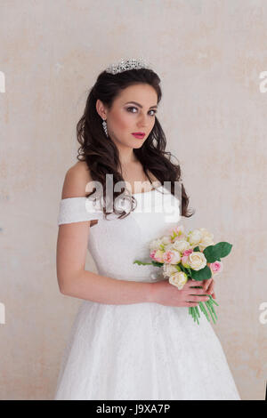 bride Princess stands in a wedding dress with flowers Stock Photo