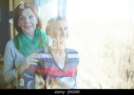 Pretty females looking at camera on sunny day by window Stock Photo