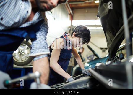 Two mechanics working in car repair service Stock Photo