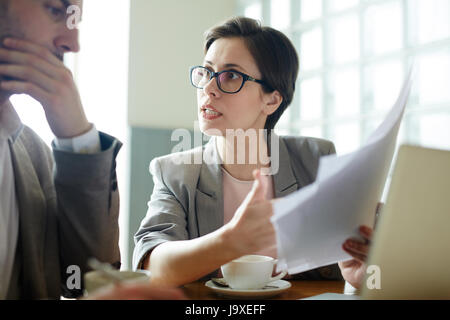 Two co-workers consulting while reading business contract Stock Photo