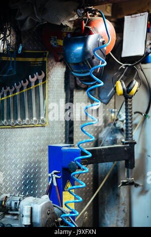 Image of empty mechanics garage with welders mask, equipment and tools on walls Stock Photo