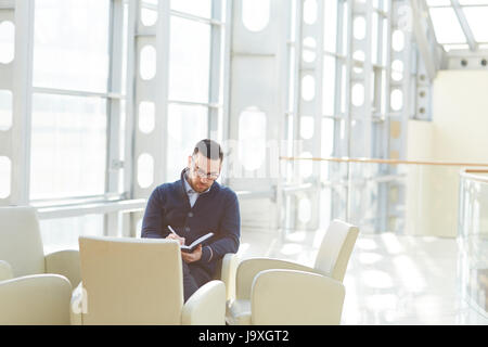 Businessman making notes in notebook Stock Photo