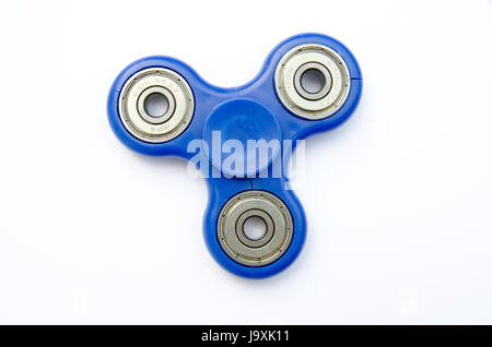 A blue fidget spinner toy on a plain white background Stock Photo