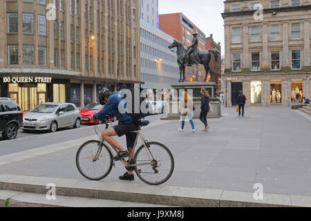 Deliveroo Uber delivery bikers cyclists drivers on the street delivering to Glasgow in view of the cone head Duke of Wellington statue Stock Photo