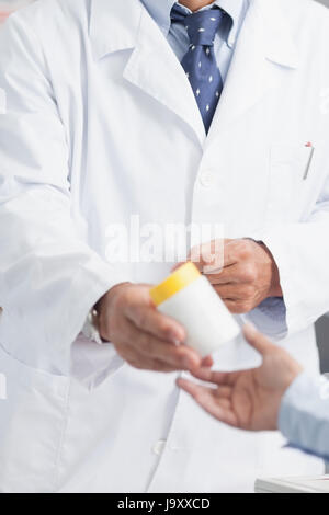 Pharmacist giving a box of pills to someone in a hospital Stock Photo