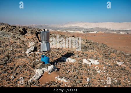 Italian Coffee maker boiling at a fireplace in the desert on camping gaz Stock Photo