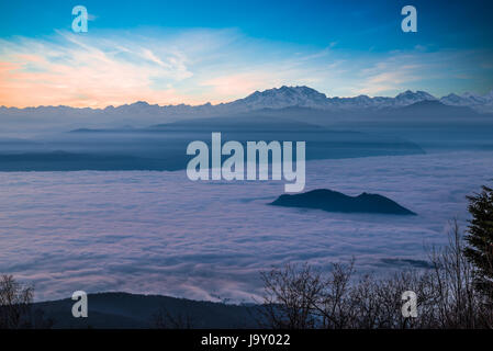 Alpine chain with Monte Rosa emerges from a sea of clouds at sunset Stock Photo