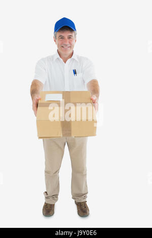 Portrait of mature delivery man handing package against white background Stock Photo